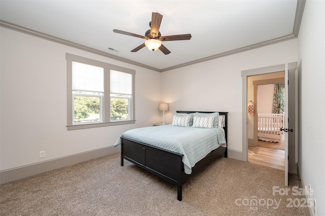 carpeted bedroom with a ceiling fan, crown molding, baseboards, and visible vents