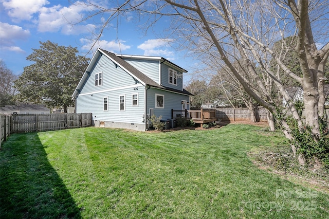 back of property with a fenced backyard, a lawn, a deck, and a shingled roof