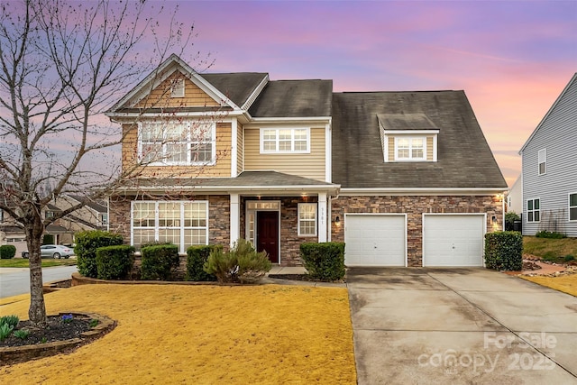 view of front facade with stone siding, an attached garage, concrete driveway, and a front lawn