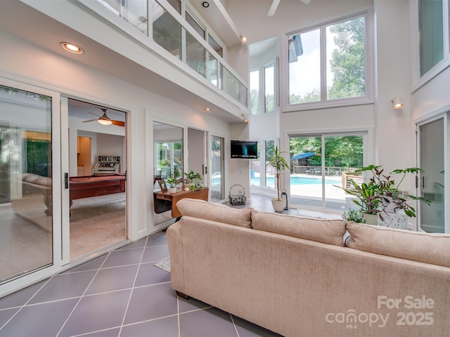 living area featuring recessed lighting, a high ceiling, dark tile patterned floors, and a ceiling fan