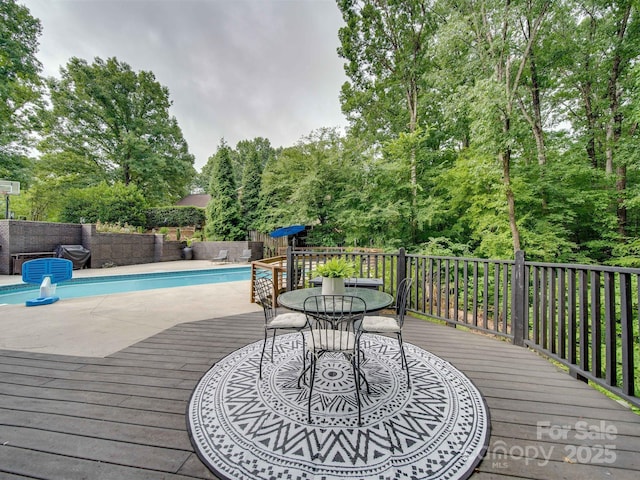 wooden deck with a fenced in pool