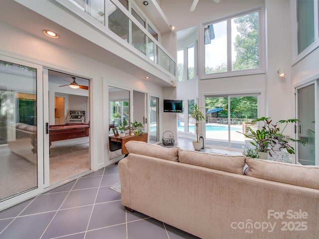 living room featuring dark tile patterned floors, a ceiling fan, recessed lighting, and a towering ceiling