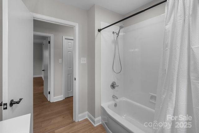 full bathroom featuring shower / bathtub combination with curtain, baseboards, and wood finished floors