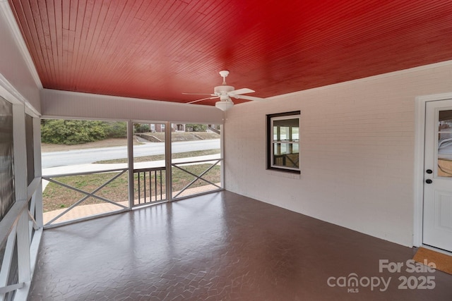 unfurnished sunroom featuring wooden ceiling and a ceiling fan