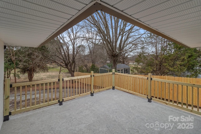 view of patio / terrace with an outbuilding and fence