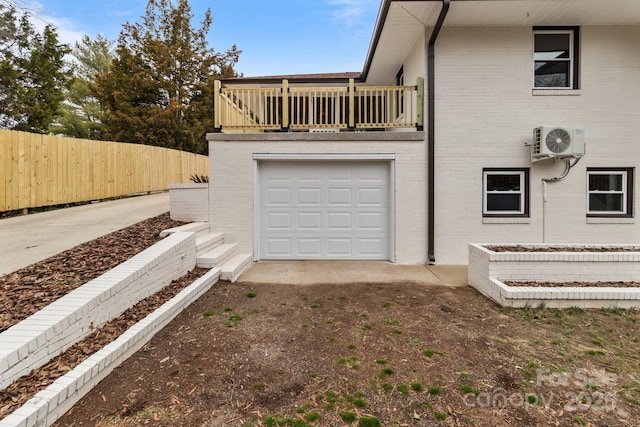 view of side of property with ac unit, driveway, a balcony, fence, and brick siding