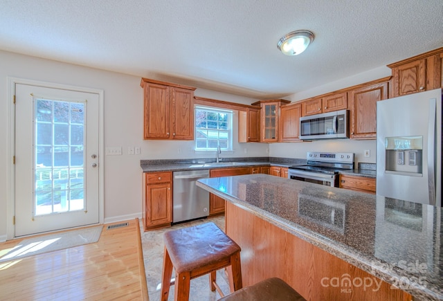 kitchen featuring visible vents, appliances with stainless steel finishes, and brown cabinetry