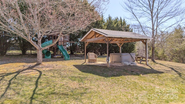 view of yard with a gazebo, a playground, and a hot tub