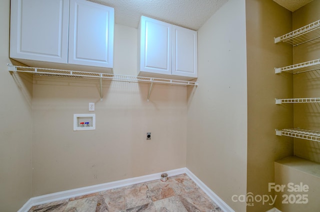 laundry area featuring baseboards, hookup for a washing machine, cabinet space, hookup for an electric dryer, and a textured ceiling