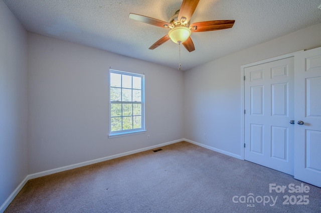 unfurnished bedroom with visible vents, baseboards, carpet flooring, a textured ceiling, and a ceiling fan