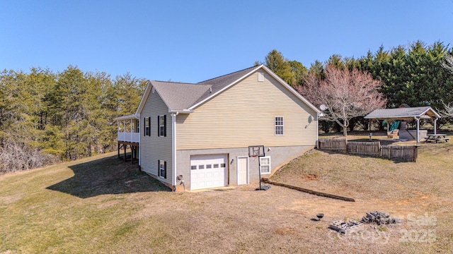 view of property exterior featuring driveway, an attached garage, and a yard