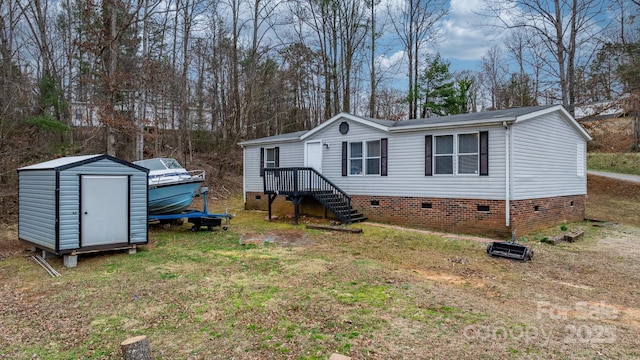 view of front of home featuring crawl space, an outdoor structure, a front lawn, and a shed