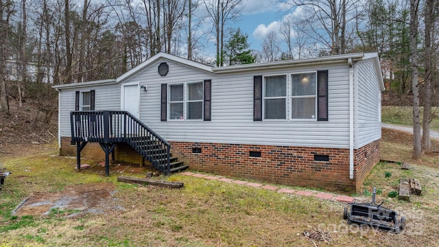 manufactured / mobile home featuring crawl space, stairs, and a front lawn