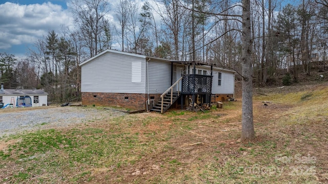 view of front facade with gravel driveway and crawl space