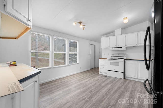 kitchen with freestanding refrigerator, white cabinetry, electric stove, and vaulted ceiling