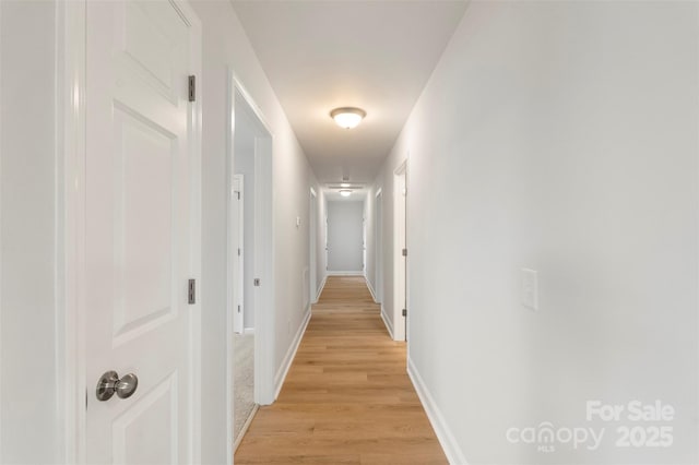 hall with baseboards and light wood-type flooring