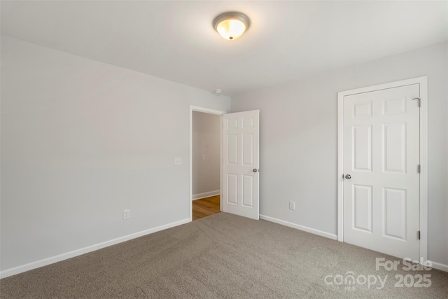 unfurnished bedroom with baseboards and carpet