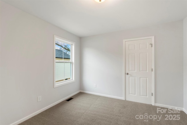 carpeted empty room with baseboards and visible vents