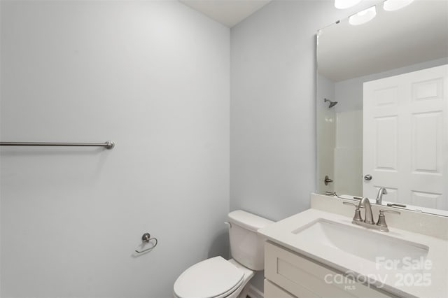 bathroom with vanity, toilet, and a shower