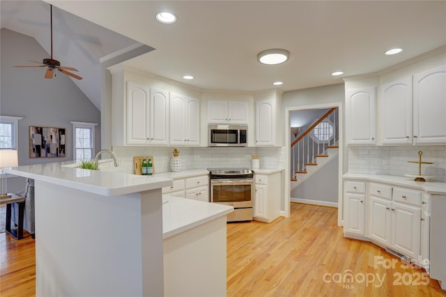 5306 Club View Dr, Concord, NC 28025 - kitchen featuring appliances with stainless steel finishes, a peninsula, white cabinets, backsplash, and recessed lighting