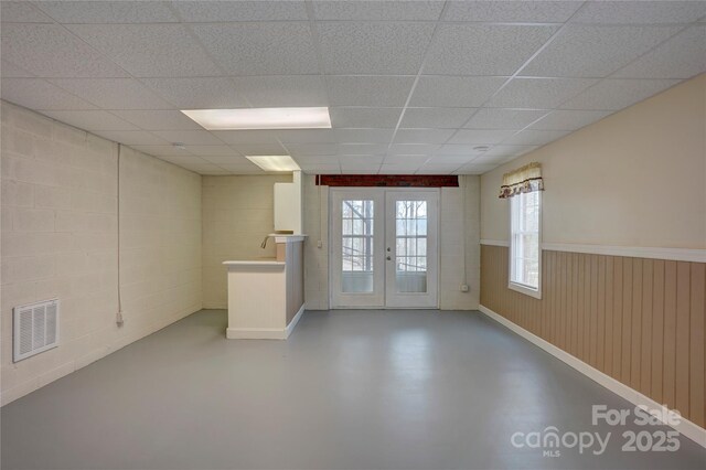 5306 Club View Dr, Concord, NC 28025 - unfurnished room featuring concrete floors, french doors, a paneled ceiling, and wainscoting