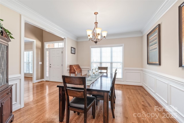 dining room with a wealth of natural light, an inviting chandelier, and light wood finished floors