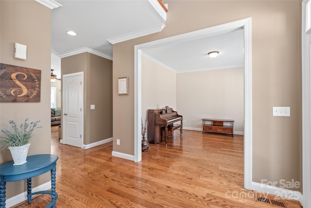 hall featuring visible vents, baseboards, light wood-type flooring, ornamental molding, and recessed lighting