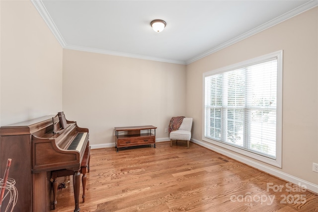 living area with light wood-type flooring, baseboards, and crown molding