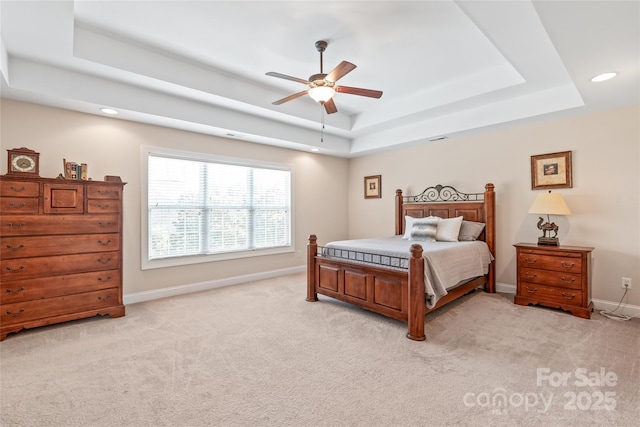 bedroom with a ceiling fan, baseboards, a tray ceiling, recessed lighting, and light colored carpet