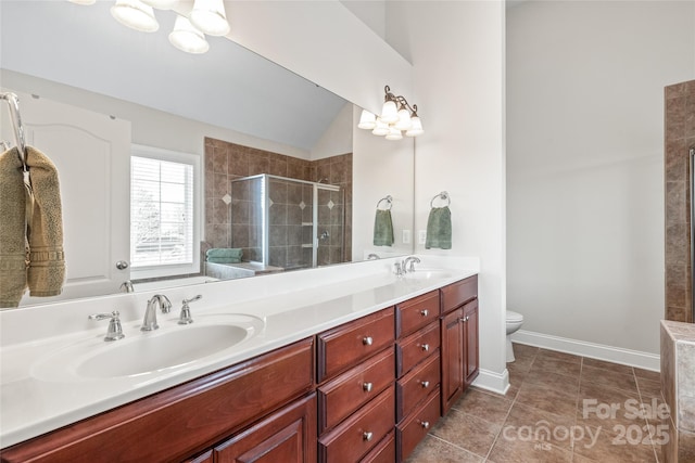 bathroom featuring toilet, double vanity, a stall shower, tile patterned floors, and a sink