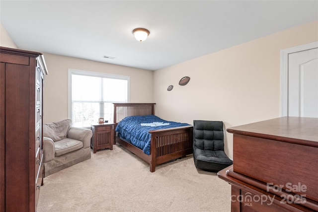 bedroom featuring light colored carpet and visible vents