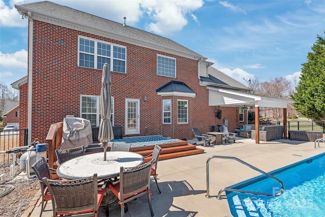 rear view of property with brick siding, a fenced in pool, outdoor lounge area, outdoor dining area, and a patio