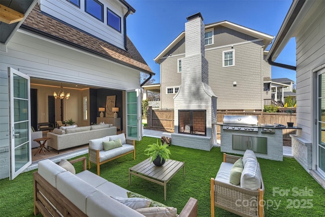 rear view of property featuring fence, area for grilling, a shingled roof, outdoor lounge area, and a lawn