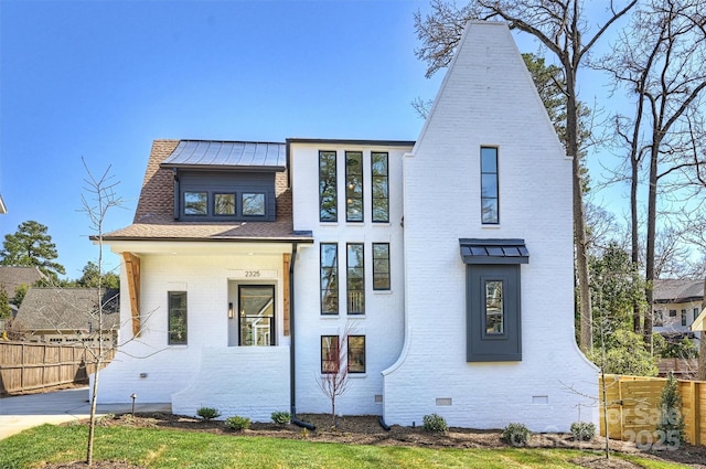view of front facade with crawl space, brick siding, and fence
