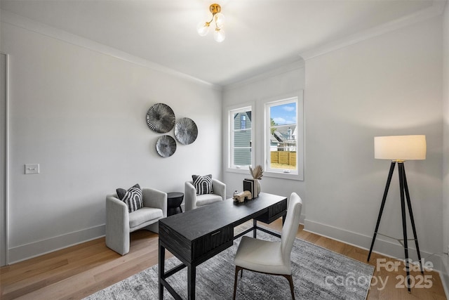 office area featuring light wood finished floors, crown molding, and baseboards
