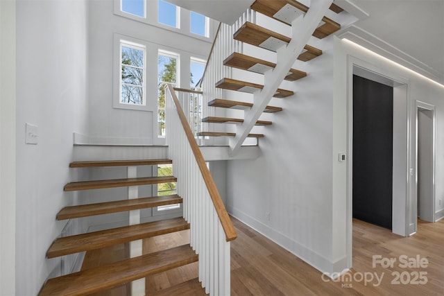stairway featuring baseboards and wood finished floors