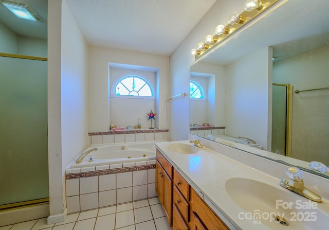 bathroom featuring tile patterned flooring, a whirlpool tub, a shower stall, and a sink