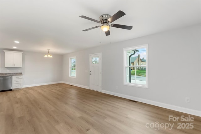 unfurnished living room featuring visible vents, baseboards, light wood finished floors, recessed lighting, and ceiling fan with notable chandelier