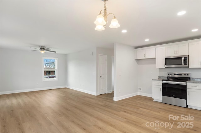 kitchen featuring light wood finished floors, recessed lighting, ceiling fan with notable chandelier, appliances with stainless steel finishes, and white cabinetry