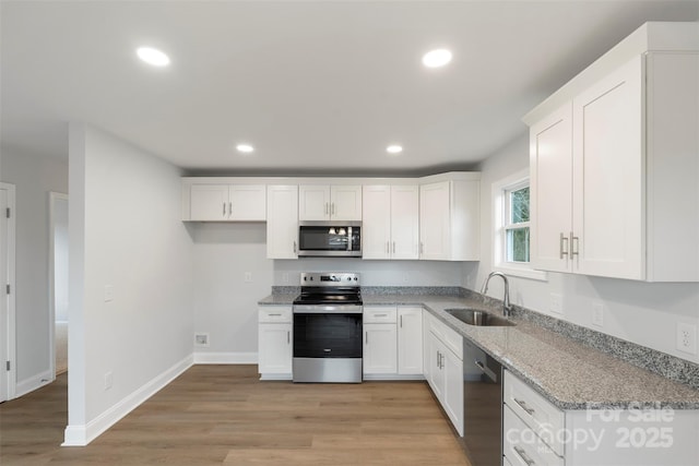 kitchen featuring a sink, recessed lighting, white cabinetry, and stainless steel appliances