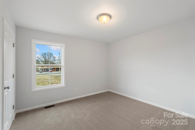 spare room featuring visible vents, carpet floors, and baseboards