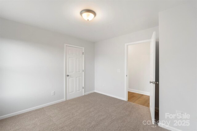 unfurnished room featuring baseboards and carpet flooring