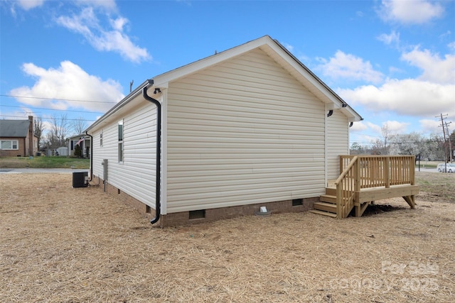 view of property exterior featuring crawl space, cooling unit, and a deck