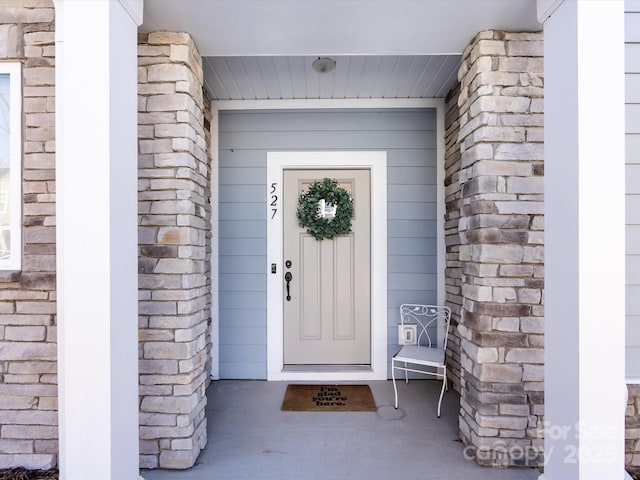 doorway to property featuring stone siding