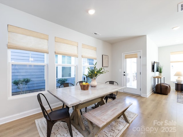 dining room with visible vents, light wood-type flooring, and baseboards