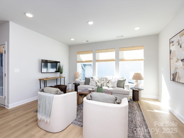 living area featuring recessed lighting, light wood-style flooring, and baseboards