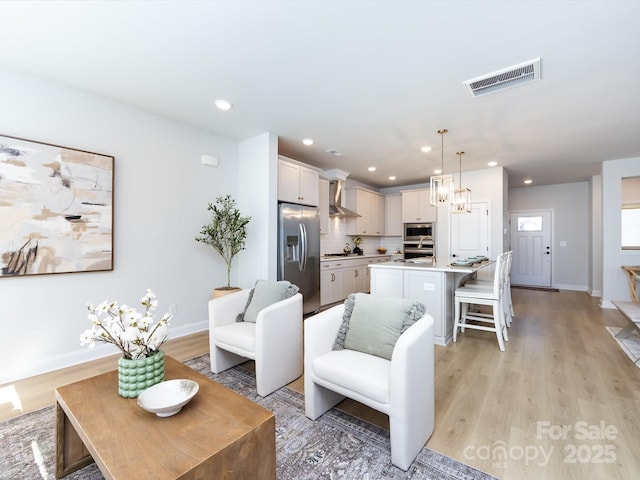 living room featuring recessed lighting, visible vents, and light wood-style floors