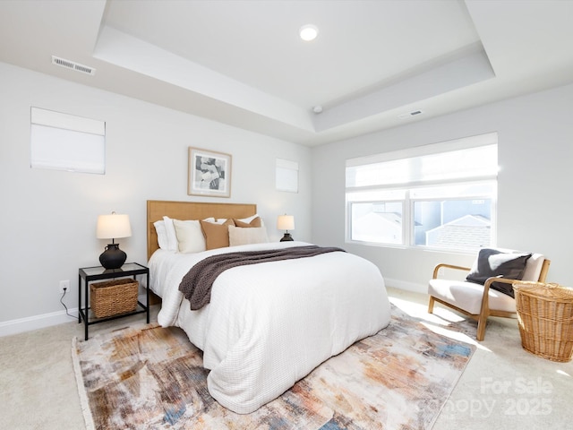 bedroom with visible vents, baseboards, a tray ceiling, and carpet floors