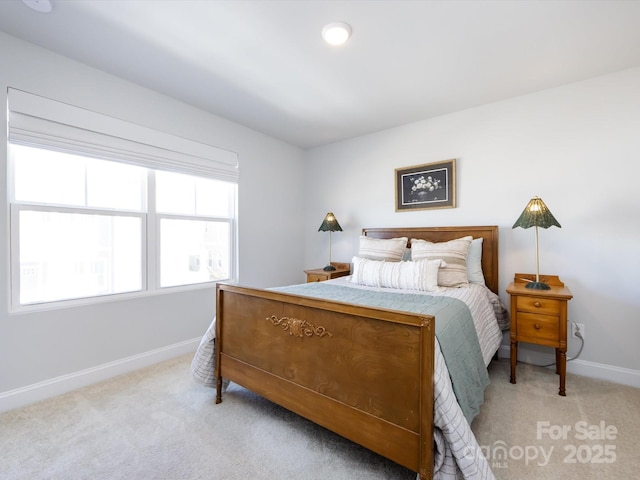 bedroom featuring light colored carpet and baseboards