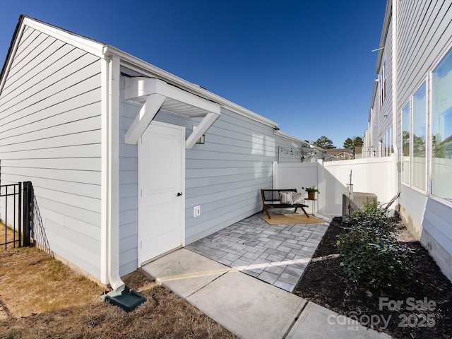 view of side of home with a patio and fence